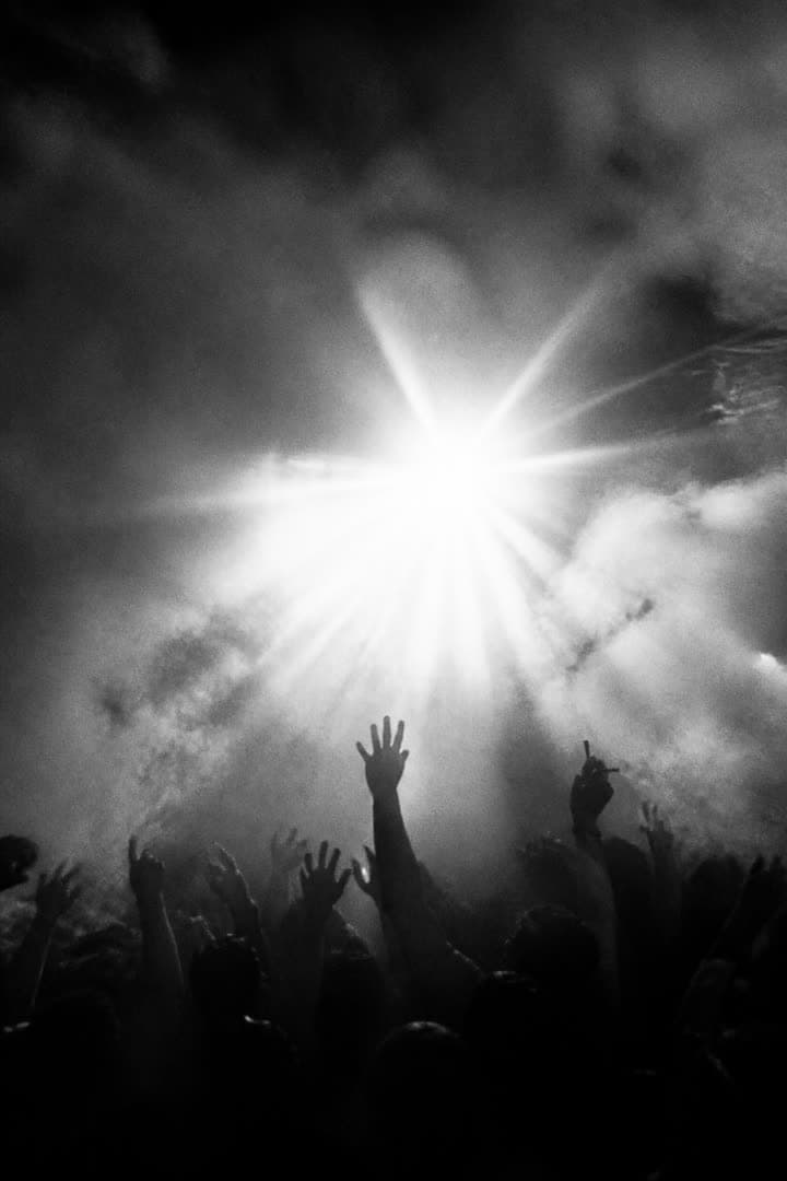 Strobe burst through haze with arms raised