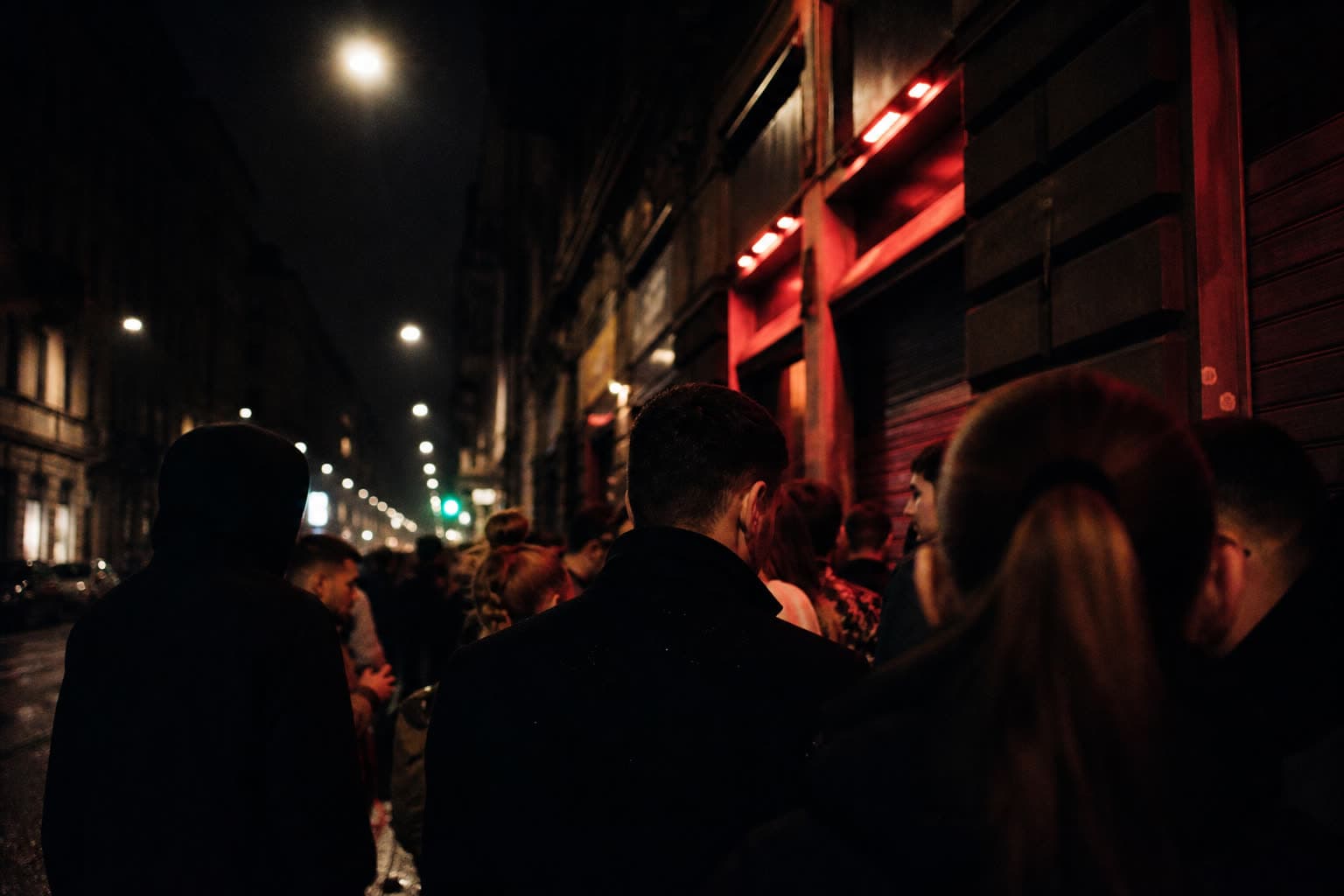 Night street reflections outside a Turin club